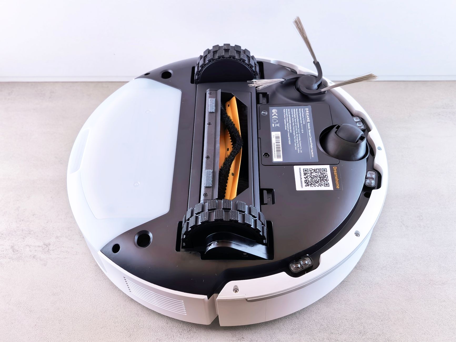 Robotic vacuum cleaner with visible sensor array navigating a modern living room floor