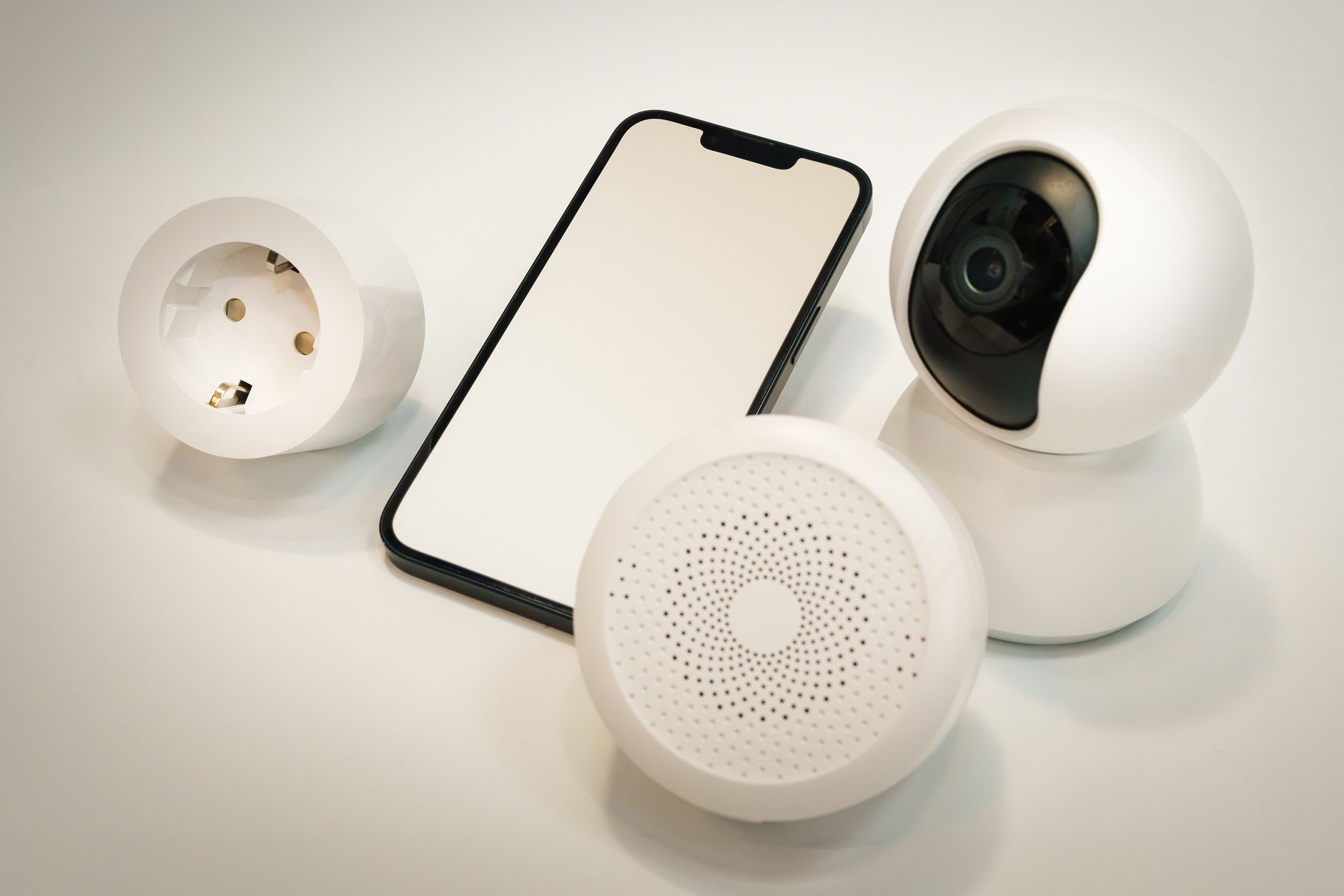 Smart home hub, smart bulb, and door lock sensor arranged on a shelf with a Thread border router